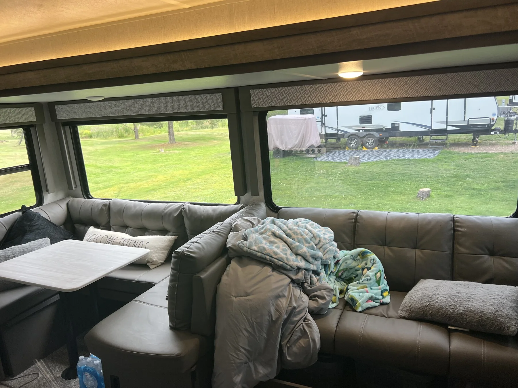 Camper lounge with wide windows above the sofa and dining area
